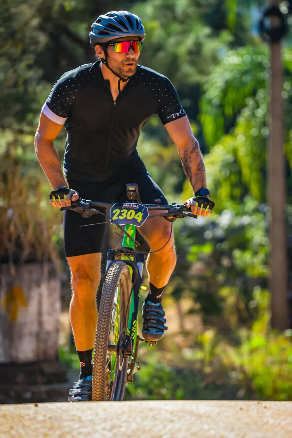 Ciclista em trecho de trilha arborizada